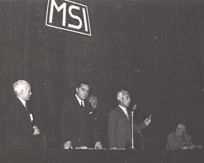 <b>Giovanni Maria Angioy</b> al microfono nel corso di un comizio del Msi, alla sua sinistra i segretari <b>Arturo Michelini</b> e <b>Augusto De Marsanich</b>